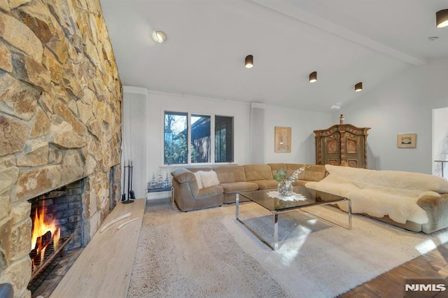 living room featuring a fireplace, lofted ceiling with beams, and hardwood / wood-style floors