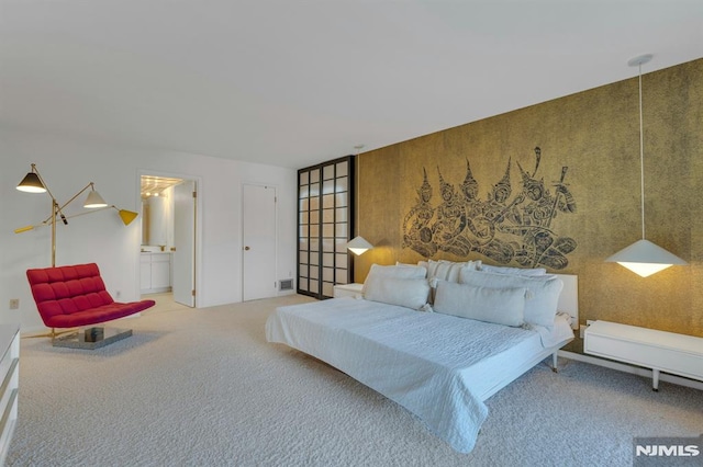 carpeted bedroom featuring wooden walls and ensuite bath