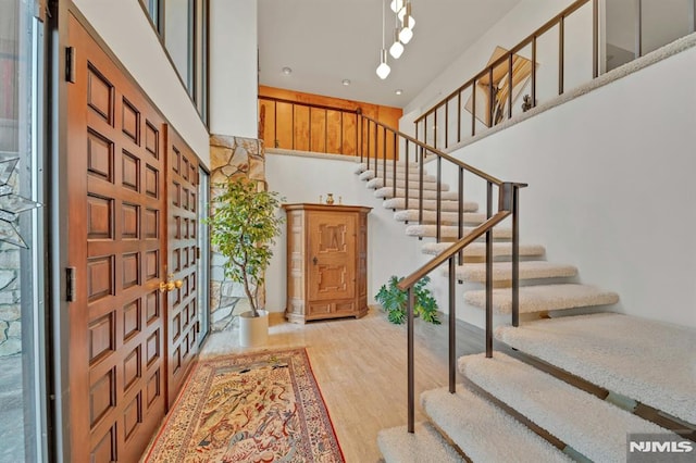 foyer featuring ornate columns and light wood-type flooring