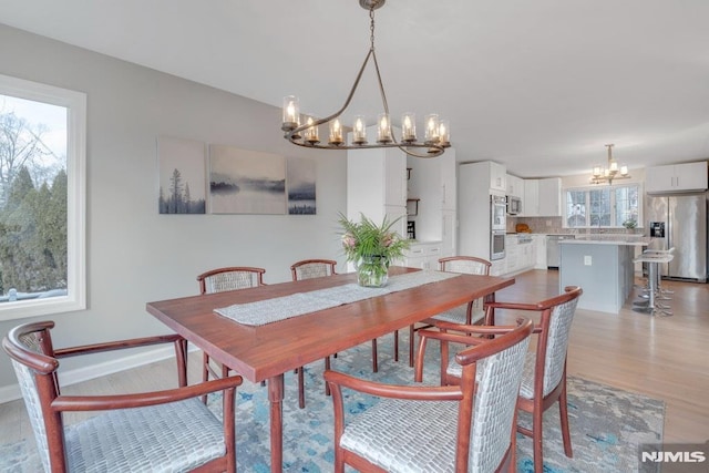 dining area featuring light hardwood / wood-style floors and a notable chandelier