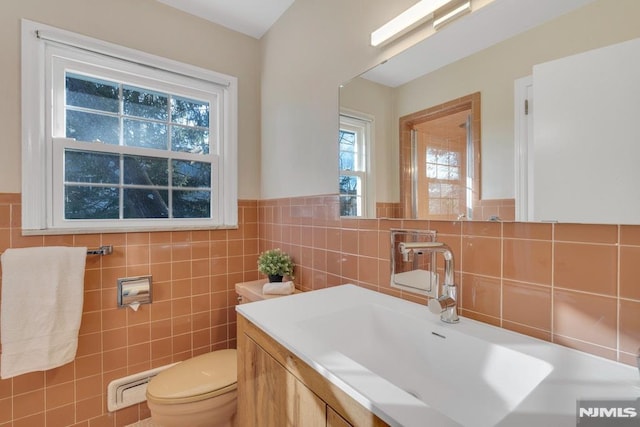 bathroom featuring tile walls, vanity, and toilet