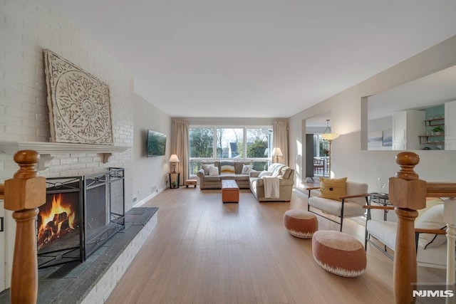 living room featuring a brick fireplace and hardwood / wood-style floors