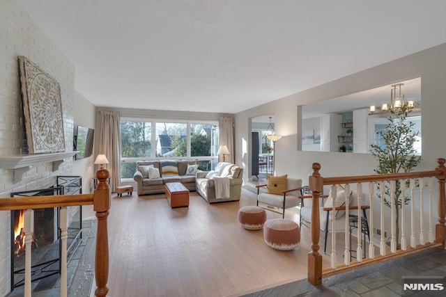 living room featuring hardwood / wood-style floors, a chandelier, and a fireplace