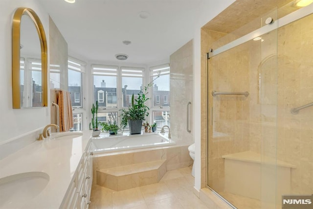 full bathroom featuring toilet, vanity, tile patterned floors, and independent shower and bath