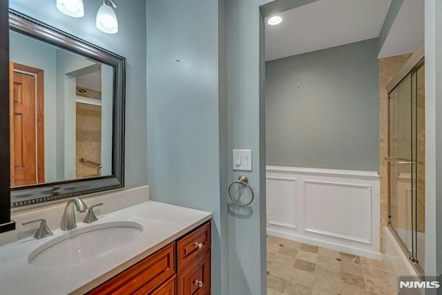 bathroom with enclosed tub / shower combo and vanity