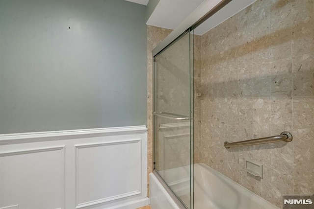 bathroom with bath / shower combo with glass door