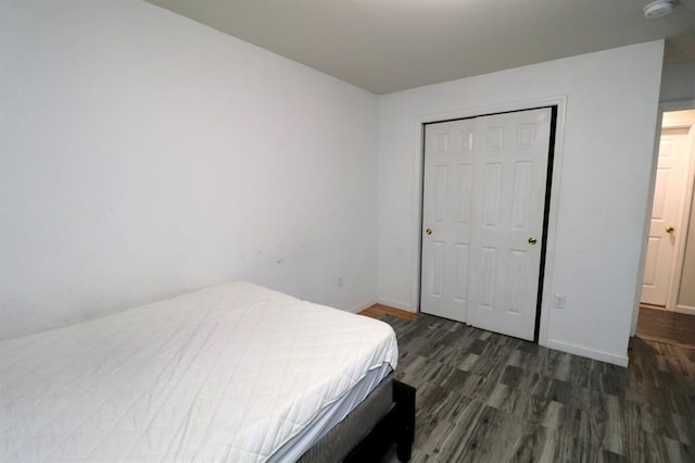 bedroom featuring dark wood-type flooring and a closet