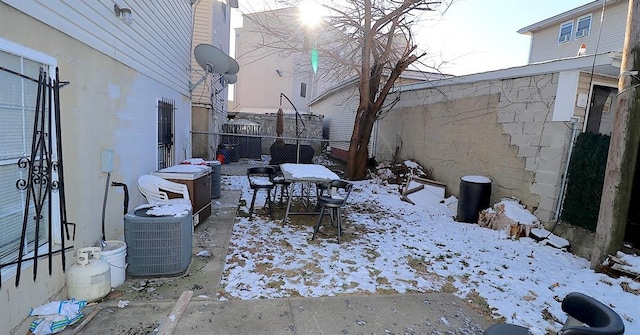 yard layered in snow with central air condition unit