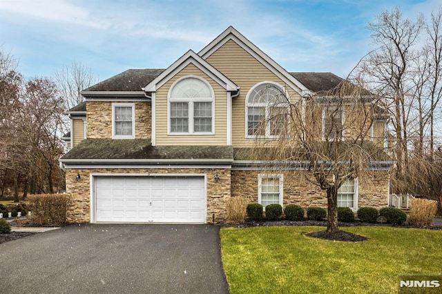 front of property with a front yard and a garage