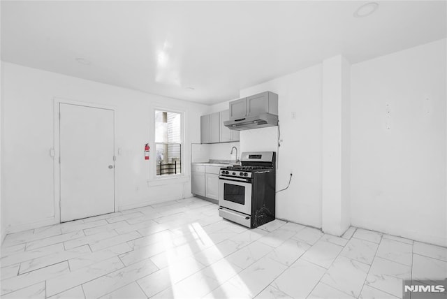 kitchen with stainless steel gas stove, gray cabinets, and sink