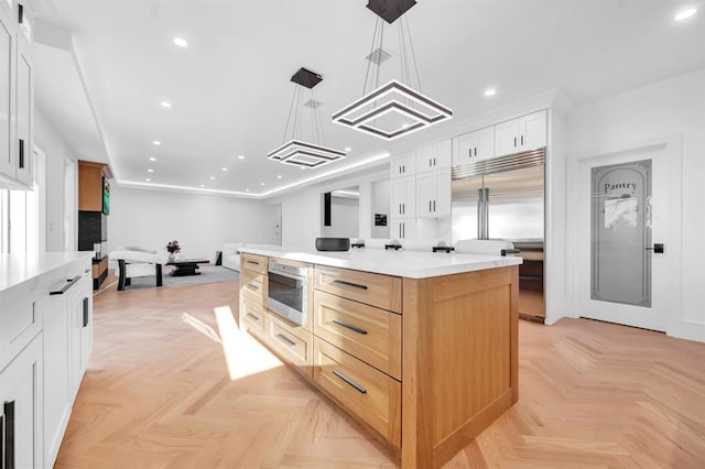 kitchen featuring white cabinets, a spacious island, and decorative light fixtures