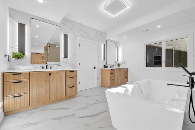 bathroom with a washtub and vanity