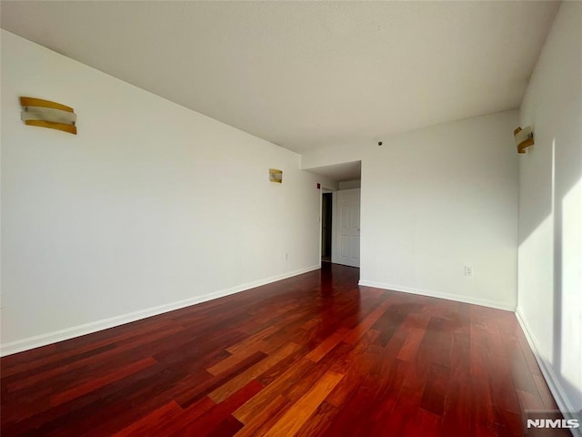 empty room featuring dark wood-type flooring