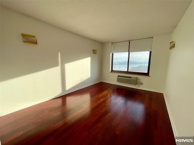 empty room with dark hardwood / wood-style floors and a wall mounted AC