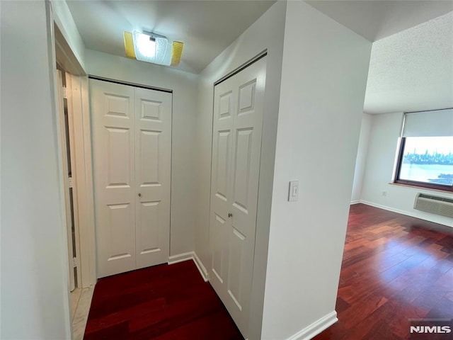 hallway featuring a wall unit AC and hardwood / wood-style floors