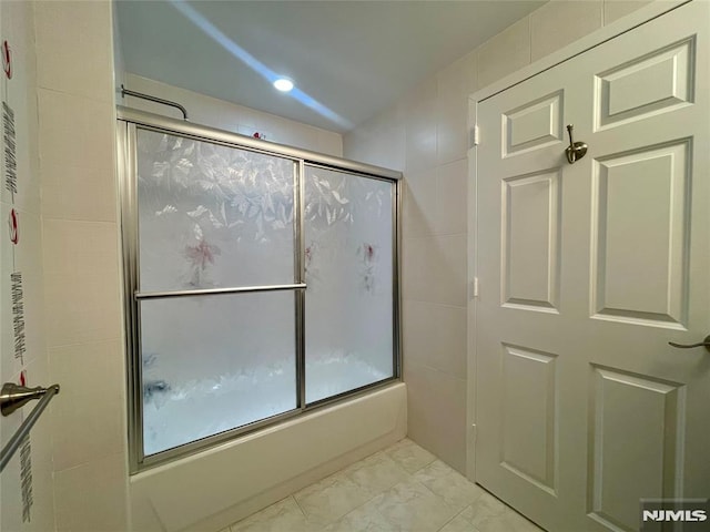 bathroom with shower / bath combination with glass door