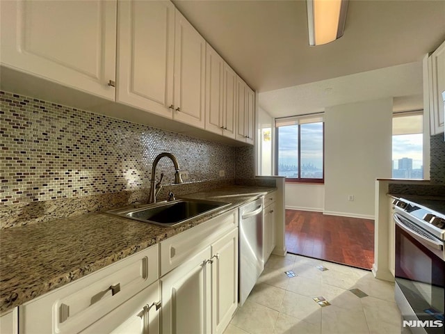 kitchen featuring appliances with stainless steel finishes, tasteful backsplash, white cabinetry, and sink