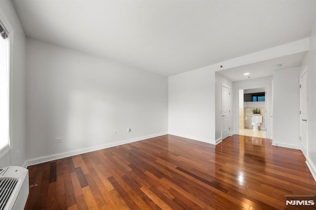 spare room with hardwood / wood-style flooring and heating unit