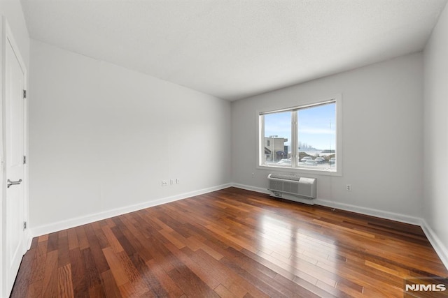 unfurnished room featuring a wall mounted air conditioner and wood-type flooring