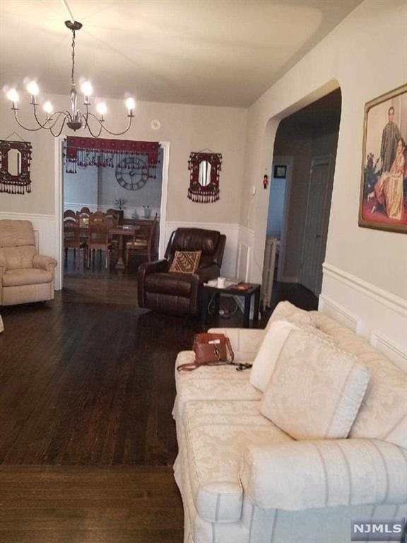living room featuring dark hardwood / wood-style flooring and a chandelier