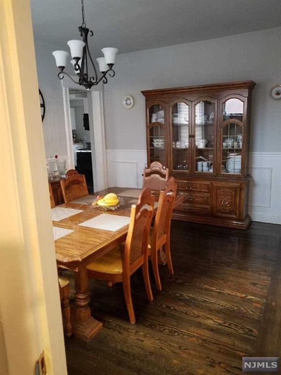 dining space with a notable chandelier and dark wood-type flooring