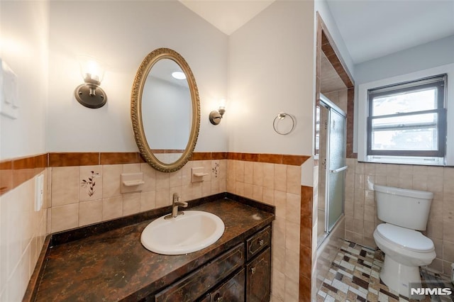 bathroom featuring tile patterned flooring, vanity, tile walls, and toilet