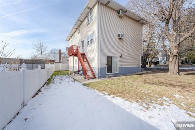 view of side of home with a lawn and an AC wall unit