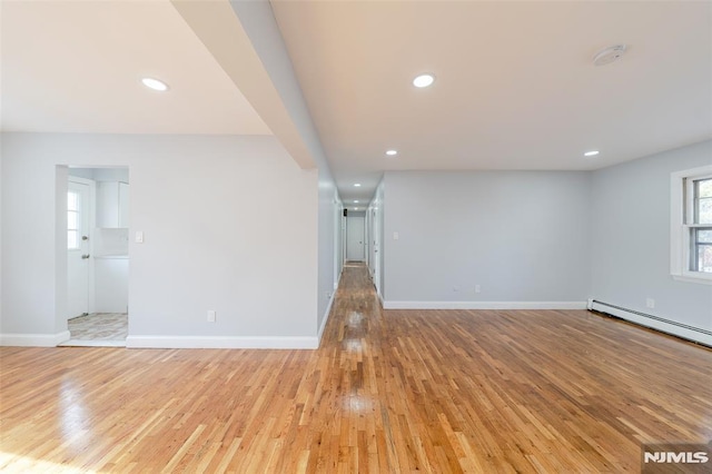 unfurnished living room featuring light hardwood / wood-style flooring and a baseboard radiator