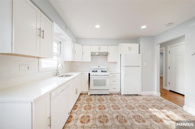 kitchen featuring tasteful backsplash, sink, white cabinets, and white appliances