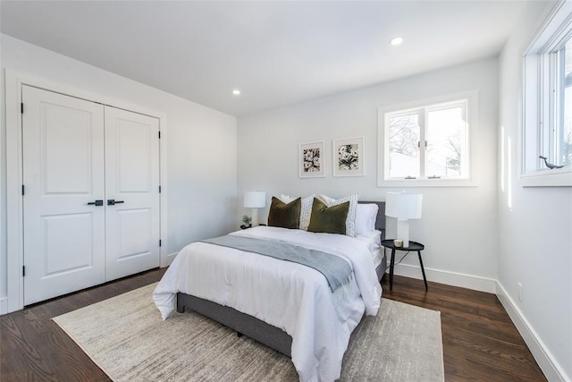 bedroom with dark hardwood / wood-style flooring and a closet