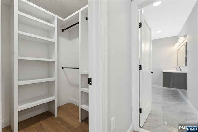 spacious closet featuring sink and light wood-type flooring