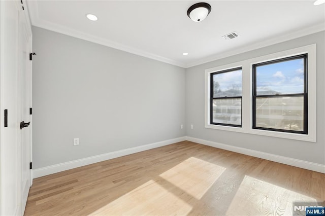 unfurnished room with crown molding and light hardwood / wood-style flooring