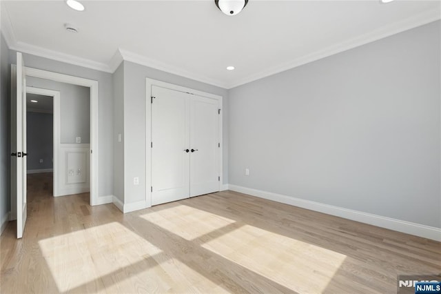 unfurnished bedroom with ornamental molding, a closet, and light hardwood / wood-style flooring