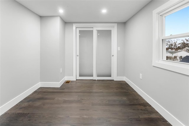 empty room featuring recessed lighting, dark wood finished floors, and baseboards