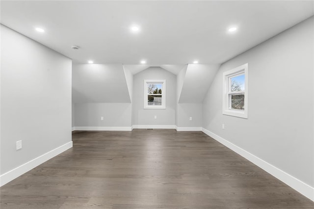 additional living space featuring lofted ceiling, baseboards, dark wood-type flooring, and recessed lighting