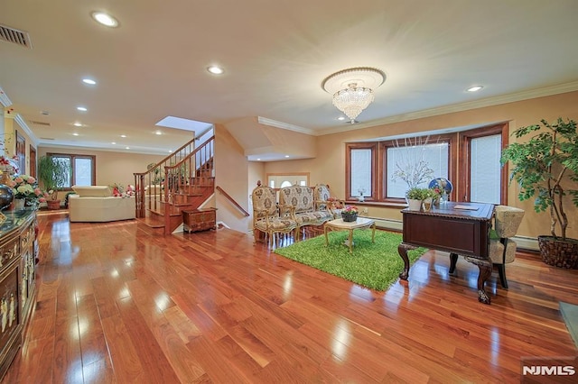 living room with a chandelier, wood-type flooring, and ornamental molding