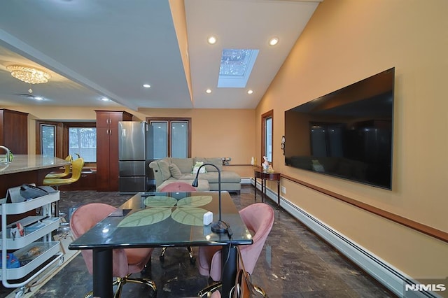 dining room with lofted ceiling with skylight, baseboard heating, and sink