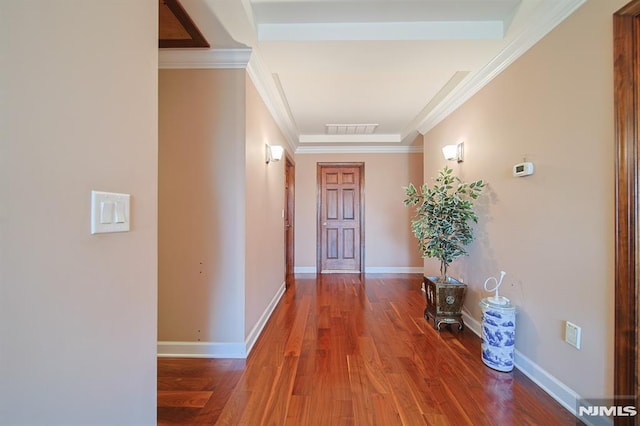 corridor with wood-type flooring and crown molding