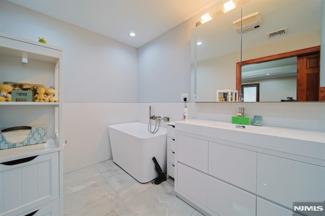 bathroom with a washtub and vanity