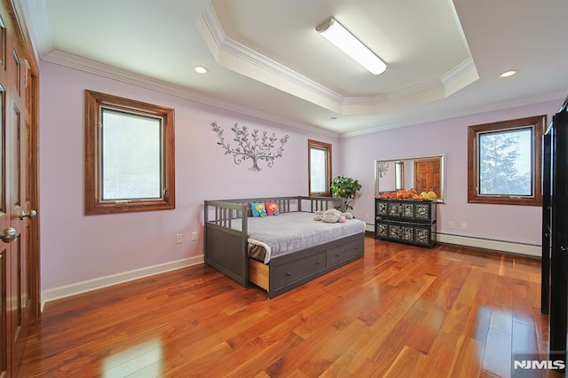 bedroom featuring crown molding, a raised ceiling, wood-type flooring, and baseboard heating