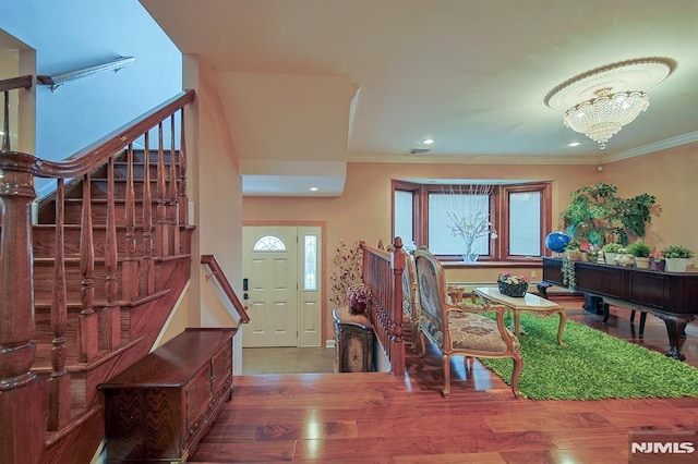 entryway featuring hardwood / wood-style floors, crown molding, and a wealth of natural light