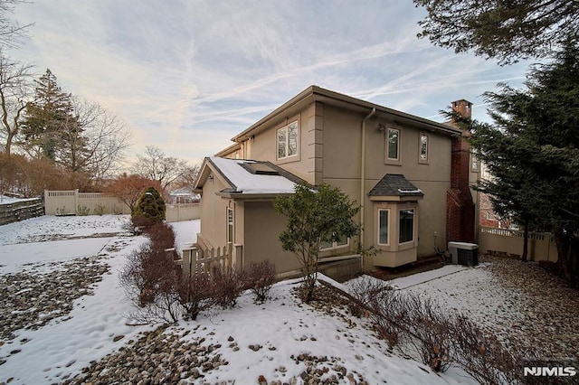 view of snowy exterior with central air condition unit