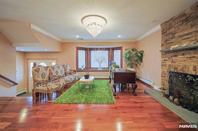 living room with hardwood / wood-style floors, a fireplace, crown molding, and a baseboard radiator