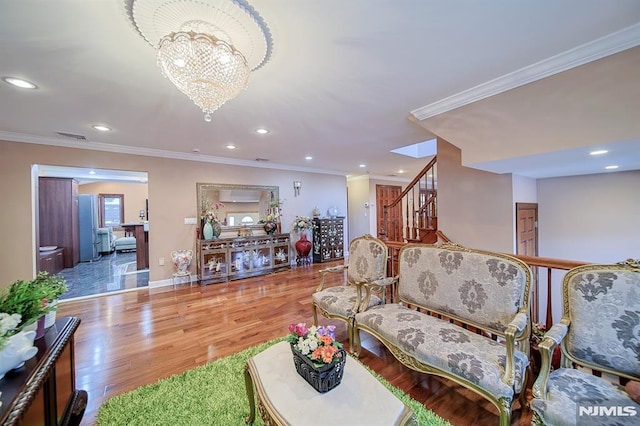 living room featuring ornamental molding, a notable chandelier, and hardwood / wood-style floors