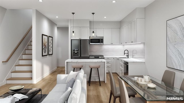 kitchen featuring decorative backsplash, white cabinetry, pendant lighting, and stainless steel appliances