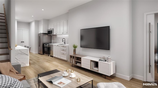 living room featuring light wood-type flooring and sink