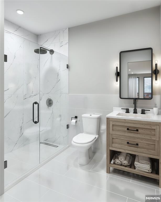 bathroom with tile patterned floors, an enclosed shower, toilet, vanity, and tile walls