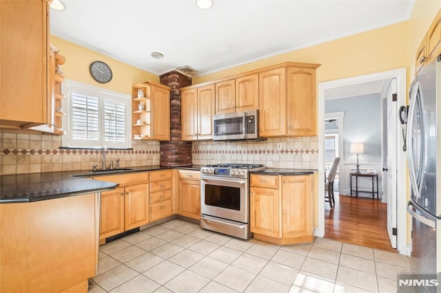 kitchen featuring appliances with stainless steel finishes, backsplash, light brown cabinetry, sink, and light tile patterned flooring