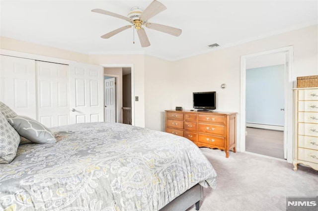 bedroom with carpet, a closet, a baseboard heating unit, and ceiling fan