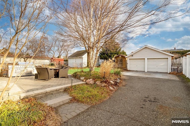 view of yard featuring an outbuilding, a garage, and a patio area